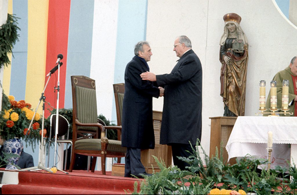 Polish Prime Minister Tadeusz Mazowiecki and German Chancellor Helmut Kohl gave each other a symbolic sign of peace